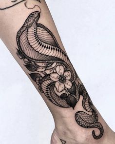 a black and white snake tattoo on the right foot, with flowers in the background