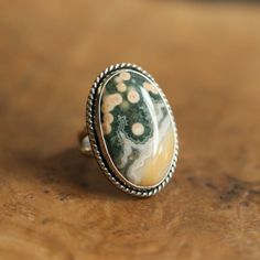 What a great, Ocean Jasper statement ring. It looks and feels like it could have been made by a master silversmith from another time and place. Simple, classic design with the .925 Sterling Silver twist wire and double round split shank. Makes you feel like you're sliding on something that someone will still wear in 50 years. You might want to make room on your hand -- you're going to want to wear this big statement ring all the time. 18X25mm oval cabochon of stunning quality Ocean Jasper All Me Silversmith Rings, Orbit Ring, Big Statement Rings, Negative Feelings, Opal Drop Earrings, Jasper Ring, Jasper Jewelry, Gold And Silver Rings, Detailed Ring