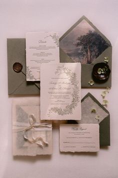 the wedding stationery is laid out on top of each other, including an envelope