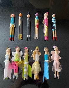 a group of wooden toy fairy figurines sitting on top of a table next to each other