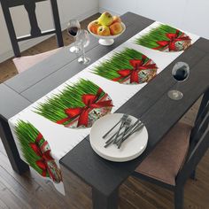 the table cloth is decorated with red bows and green grass, while silverware sits next to it