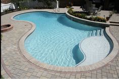 an empty swimming pool surrounded by brick pavers