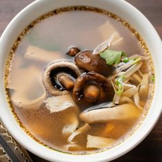 a bowl of soup with mushrooms and noodles