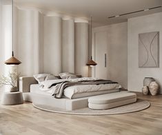 a large bed sitting on top of a hard wood floor next to a wall mounted lamp