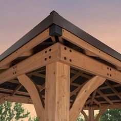 a wooden gazebo with metal roof in the evening