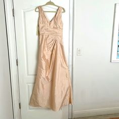 a dress hanging on a door in front of a white door with a brown carpet