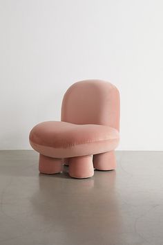 a pink chair sitting on top of a cement floor