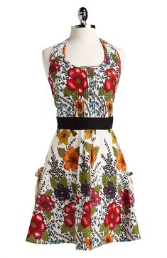 a mannequin wearing a dress with flowers and leaves on the front, black belt