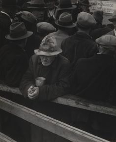 a group of people sitting in the back of a truck with hats on and one person holding a cup