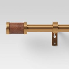 an image of a gold curtain rod with leather handle on the top and bottom bars