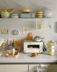 a white microwave sitting on top of a kitchen counter next to a shelf filled with dishes