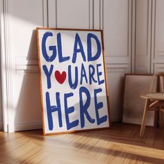 there is a sign that says glad you are here on the floor next to a chair