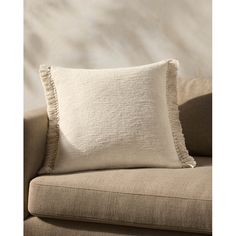 a white pillow sitting on top of a couch