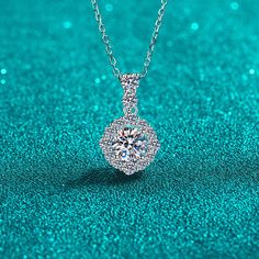 Expertly crafted with a round halo design, this 1-carat moissanite pendant features a pave bail on a S925 necklace. Experience the brilliance of moissanite, a lab-grown gemstone with 10% more sparkle than a diamond, at an affordable price. Upgrade your jewelry collection with a touch of luxury. GRA Certificate & Deluxe Gift Box included. Contact us if you want to customize your design. AZ873-X Luxury Diamond Necklace With Halo Design As Gift, Luxury Halo Diamond Necklace Gift, Moissanite Necklace With Halo Design In Diamond White, Moissanite Pendant Necklace With Halo Setting, Moissanite Round Pendant Necklace With Halo Setting, Moissanite Pendant Necklace With Halo Design, Moissanite Necklace With Round Pendant And Halo Design, Round Moissanite Solitaire Necklace With Halo Setting, Dazzling Moissanite Halo Diamond Necklace