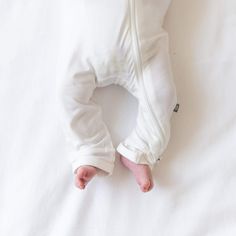 Finding the perfect sleep-to-play outfit has never been easier than with a zippered romper from Kyte Baby. This piece is great for all-day wear but also meets all safe sleep requirements from the American Academy of Pediatrics for cozy nights. With stretchy material for wiggly babies and dual zippers for quick changes, this zippered romper helps your little one stay comfy all day and night. Our rayon made from bamboo is buttery soft and hypoallergenic, even helping to alleviate signs of eczema i White Cotton Footie For Playtime, White Cotton Footie For Sleep, Soft Cotton Onesie For Bedtime, Soft Cotton Onesie For Sleep, Soft Cotton Bedtime Onesie, Cotton Onesie For Sleep, Soft White Onesie For Playtime, Fitted White Long Sleeve Footie, White Fitted Long-sleeve Footie