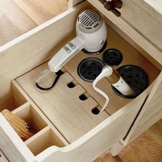 a hairdryer and brush are sitting in a drawer with other items on it