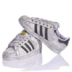 Adidas Superstar Bright Silver is the custom delicate and bold women's sneaker. Completely washed in silver with a white and silver glitter back and eyelets and gray satin laces. &nbsp;Adidas Superstar Bright Silver will also come with its original white laces. Silver Sneakers For Streetwear With Speckled Midsole, Silver Sneakers With Speckled Midsole For Streetwear, Metallic Sneakers With Speckled Midsole For Streetwear, Metallic Low-top Sneakers With Speckled Midsole, Silver Lace-up Sneakers With Vulcanized Sole, Low-top Glitter Sneakers For Sports, Silver High-top Sneakers With Vulcanized Sole, Metallic Low-top Sneakers With Vulcanized Sole, Sporty Glitter Sneakers For Streetwear