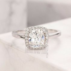 an engagement ring with a cushion cut diamond in the center