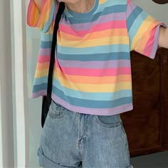 a woman wearing a colorful striped shirt and holding a cell phone up to her ear