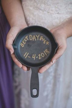 a person holding a cast iron skillet with the words best day ever written on it