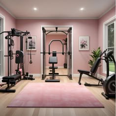 a home gym with pink walls and wooden floors