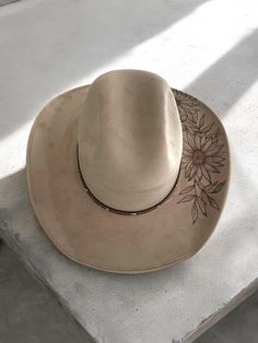 Howdy y'all! Introducing our latest handmade creation: a stunning tan suede cowboy hat in a size medium, featuring a custom sunflower burned pyrography design. 🌻🔥 This unique piece is perfect for adding a touch of boho chic to your outfit or stand out at your next music festival. 🎶 Get ready to turn heads and soak up the sun in style with this one-of-a-kind cowboy hat!  #Handmade #CowboyHat #SunflowerDesign #BohoChic #EtsySeller Cowboy Hut, Pyrography Designs, Apple Jack, Country Stuff, Painted Hats, Chapeau Cowboy, Hat Handmade, Sunflower Design, Tan Suede