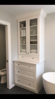 a bathroom with a tub, toilet and cabinet in it's centerpieces