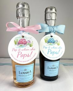 two bottles of pop it under the pops on a white tablecloth with pink and blue ribbon