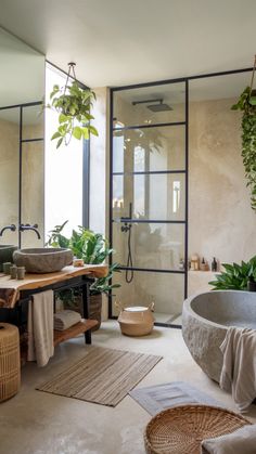 a large bathroom with plants in the bathtub and rugs on the floor next to it