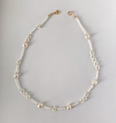 Dainty White Pearl Necklaces, Minimalist White Pearl Beaded Necklaces, Delicate White Beaded Necklace With Pearl Charm, Delicate White Pearl Beaded Necklaces, Delicate White Pearl Beaded Necklace, Delicate White Pearl Necklace, Delicate Pearl Necklace With Flower Charm, White Flower Necklace With Tiny Beads For Gift, Delicate White Pearl Necklace With Tiny Beads