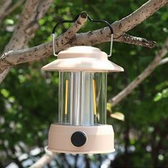 a white bird feeder hanging from a tree branch