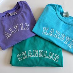 Best selling comfort colors tees paired with your little one's name in a cute curved varsity font. Made from 100% cotton, garment dyed, and super cozy! Your little one will make a statement in this tee! If you are wanting a different design, more wording, or a different clothing style, please send me a message so we can discuss the details. Cotton T-shirt With Letter Embroidery For College, Casual Blue T-shirt With Letter Embroidery, Blue Embroidered College T-shirt, School Spirit T-shirt With Embroidered Graphics, Casual School T-shirt With Embroidered Graphics, Family Matching White T-shirt With Embroidered Text, White Family Matching T-shirt With Embroidered Text, Family Matching Cotton Tops With Custom Embroidery, Cotton Tops With Embroidered Graphics For School Spirit