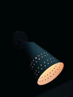 a black and white lamp in the dark with spots on it's light bulb