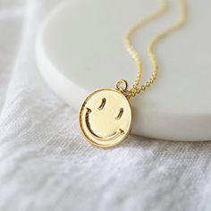 "Beautiful and lovely happy face charm necklace. Made of gold smiley face charm with skinny gold plated brass chain. Soft and warm. Great for gift , everyday or special occasion. Your item will ship in a gift box. Please feel free to contact me if you have any question. ♥ Length 14\" -20\" chain ♥ Charm 5/8\" x 3/4\" ♥ Gold plated over brass ♥ Delivery Time Fast shipping within 1 - 3 days ♥ See more Rudiana Accessories Rudiana.etsy.com" Cheerful Smiley Face Jewelry For Everyday, Fun Gold Necklace For Gift, Cheerful Smiley Face Jewelry As Gift, Personalized Fun Gold Necklaces, Handmade Gold Charm Necklaces With Fun Style, Handmade Gold Charm Necklaces, Pretzel Necklace, Smiley Face Necklace, Prom Necklaces