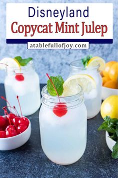 three mason jars filled with lemonade and cherries on top of a black table