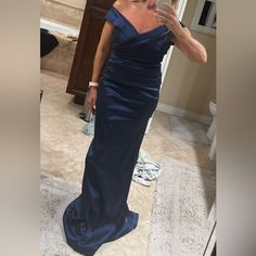 a woman in a blue dress taking a selfie