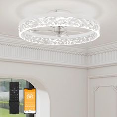 a white ceiling light with remote controls in the center and an orange phone on the other side