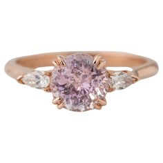 Experience timeless elegance with our captivating GIA Certified 1.92 Carat Round Pink Sapphire Ring, a stunning 3-stone engagement ring complemented by Pear Shaped Diamonds, delicately set in 14K rose gold. Immerse yourself in the allure of the natural, unheated light purplish pink sapphire, measuring 7.03-7.17x4.97mm and weighing 1.92 carats. Flanked by two pear-shaped diamonds with an approximate carat weight of 0.14, each measuring 3.8x2.2mm, this ring exudes sophistication and charm. Sized at 6 and resizable free of charge, it offers a perfect fit for your special moment. Elevate your personal touch with custom engraving options, adding a unique flair to this timeless treasure. Revel in the beauty of everlasting love with this exquisite symbol of refined elegance. Center Stone: 1.92 Ca Stone Diamond Ring, Three Stone Diamond Ring, 3 Stone Engagement Rings, Crystal Goddess, Pink Sapphire Ring, Alien Vs, Three Stone Diamond, Stone Engagement Rings, Stone Engagement