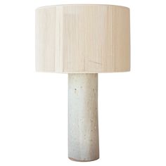 a white table lamp with a beige shade