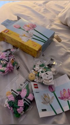 there are many different items on the bed and one is in plastic bags with flowers