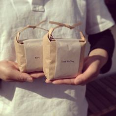 two people holding small bags in their hands with words printed on the handles and sides