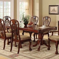 a dining room table and chairs with an area rug