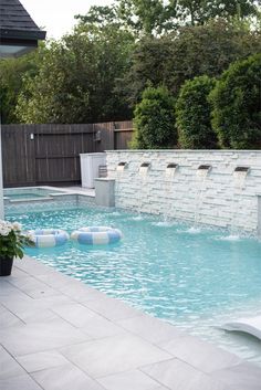 an outdoor swimming pool with artificial water features