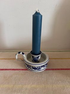 a blue candle sitting in a bowl on top of a table