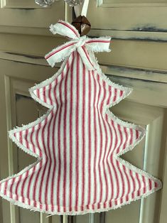 a red and white striped christmas tree hanging from a door