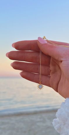 The necklace you need when you're craving that summer sun. This dainty charm necklace features a golden sun charm with pearly white enamel in the center that sparkles in the sunlight. It's the perfect combination of sparkling and beachy, just like your favorite summer days. Wear alone as an everyday piece or layer with our ocean-inspired necklaces to bring the beach home with you. Necklace features: 14k gold plated or 14k gold filled chain 16 inches in length with 2-inch extender chain Dainty 24 Preppy Tropical, Beachy Necklace, Coastal Jewelry, Surf Jewelry, Beachy Jewelry, Preppy Jewelry, Sun Charm, Golden Sun, Jewelry Accessories Ideas