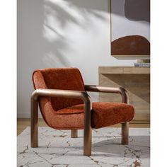 an orange chair sitting on top of a rug in front of a white and brown wall