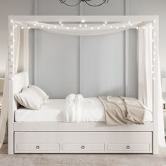 a white canopy bed with lights on the headboard and foot board in front of it