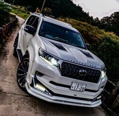 a white suv parked on the side of a dirt road