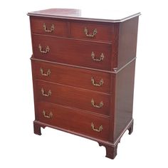 an antique chest of drawers with brass handles